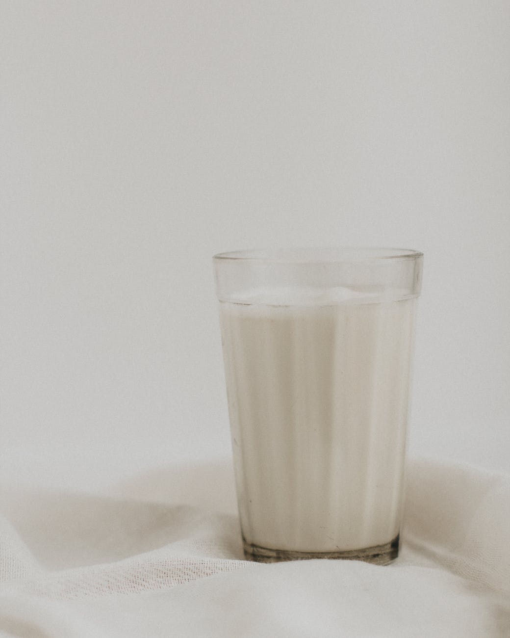 faceted glass of fresh milk on white cloth